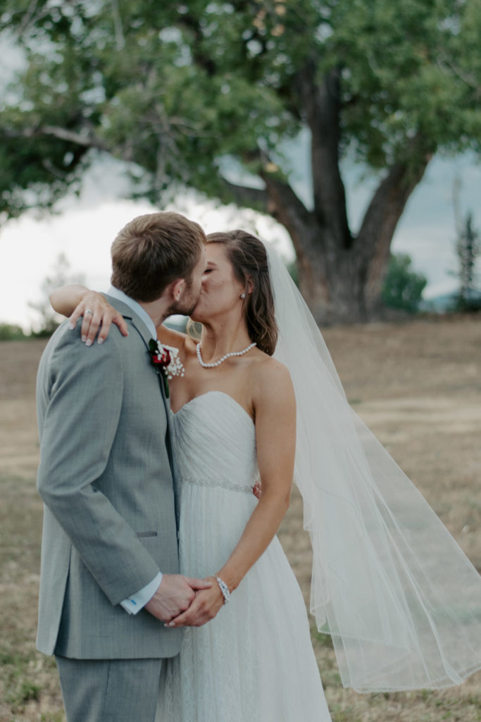 Kisses between bride and groom at Northern Colorado Wedding
