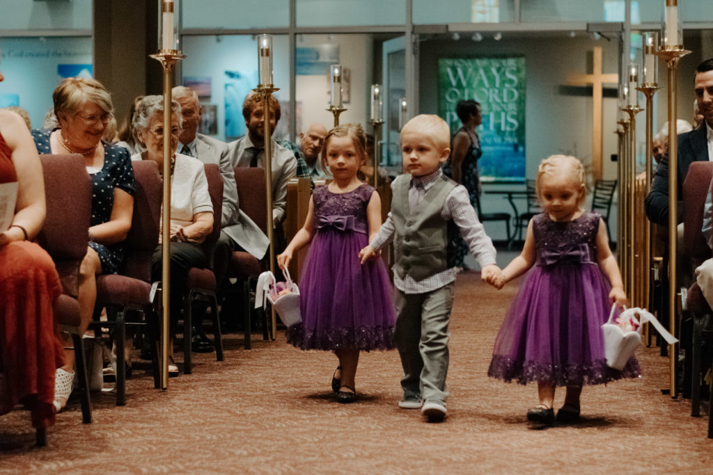 Flower girls and ring bearers walk down the aisle 
