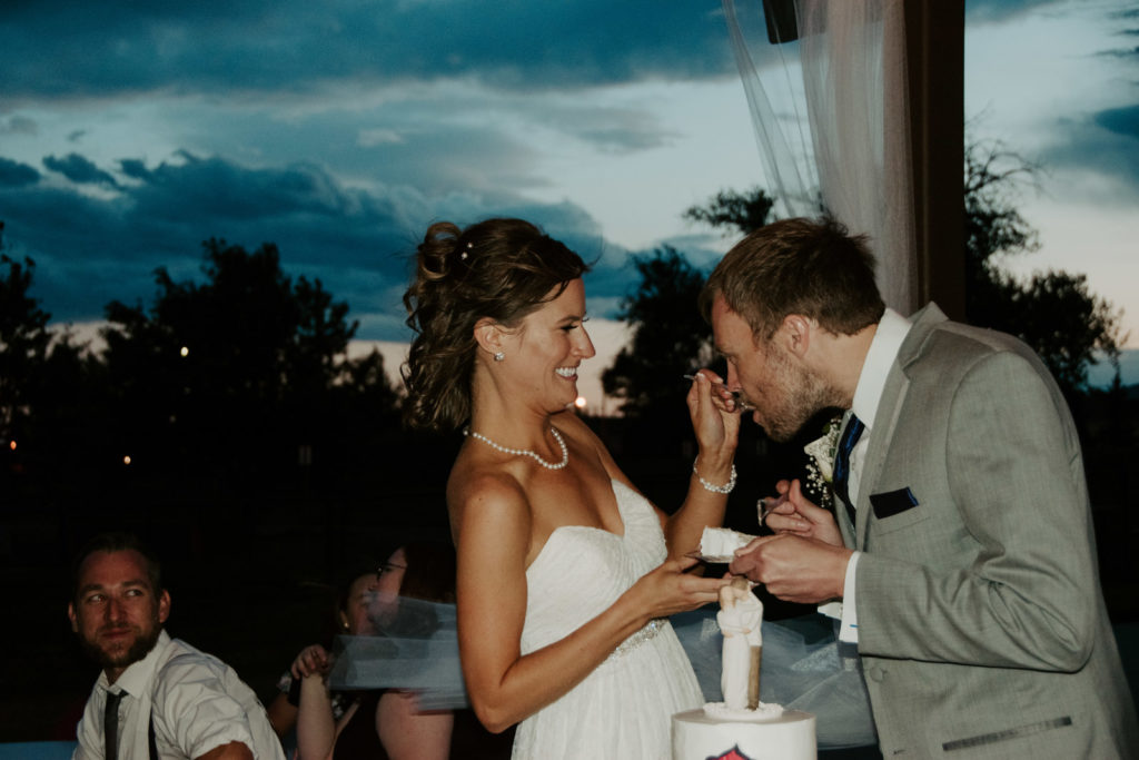 Feeding each other cake under the stars at Northern Colorado Wedding