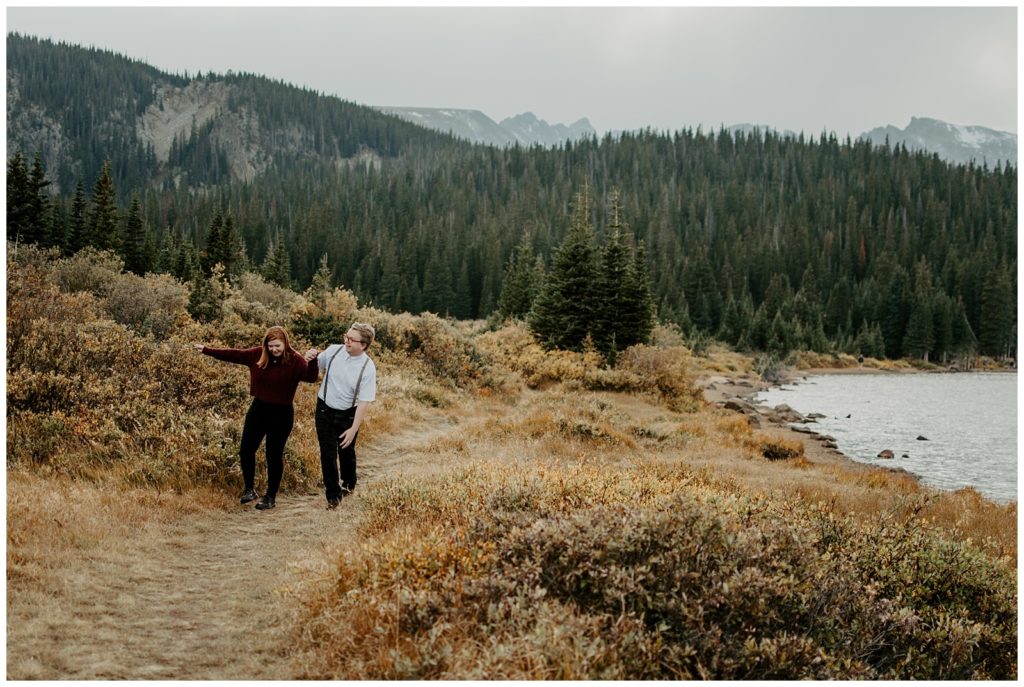 Engaged couple walks around Brainard Lake on the hiking trail