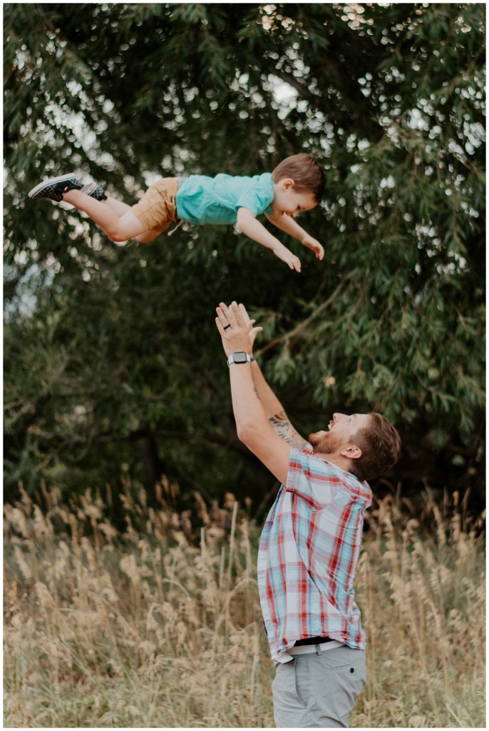 Dad throws son into the air making for a great photo