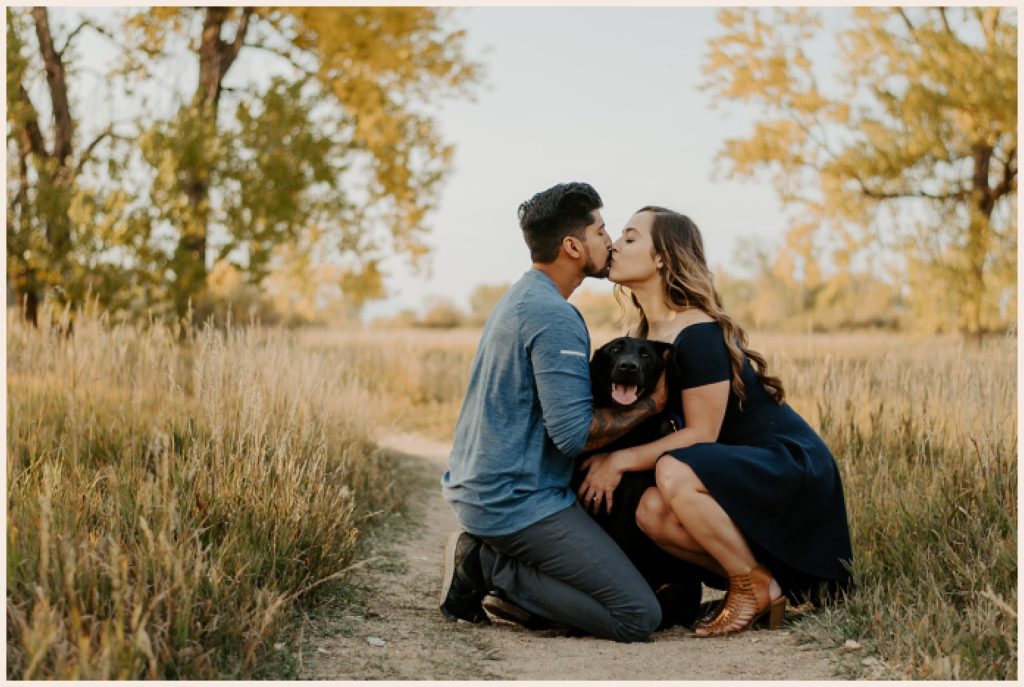 Couple kisses over their dog