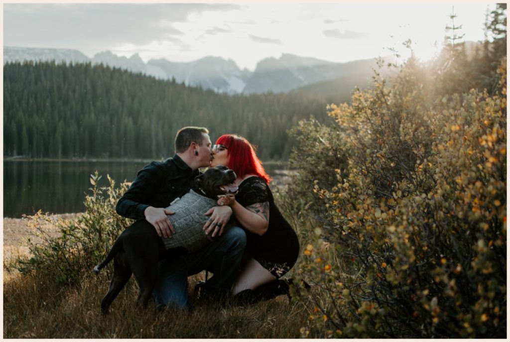 Couple kisses during engagement session with their dog