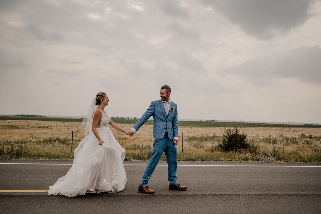 Couple walks on road at Colorado outdoor wedding
