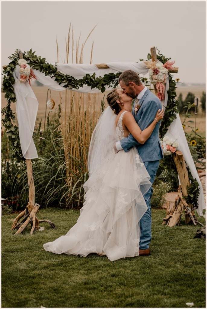 Couple kisses at the end of the ceremony at their outdoor wedding in Colorado