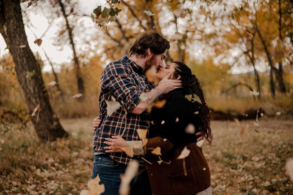 Fall engagement photos in colorado with falling leaves
