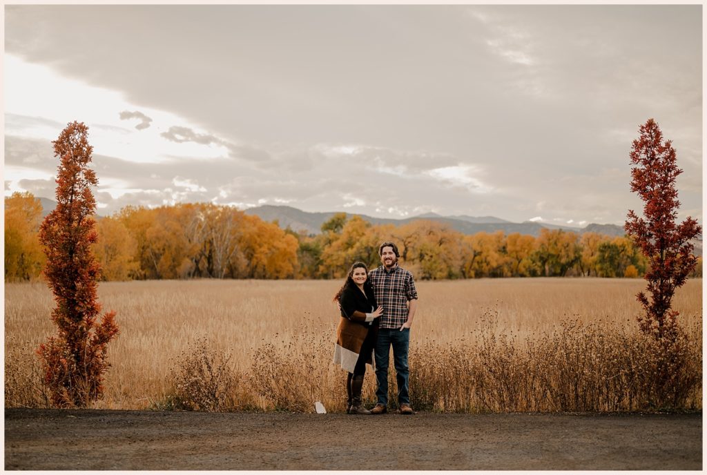 Couple stand in front of a stunning mountain view during Colorado fall engagement session