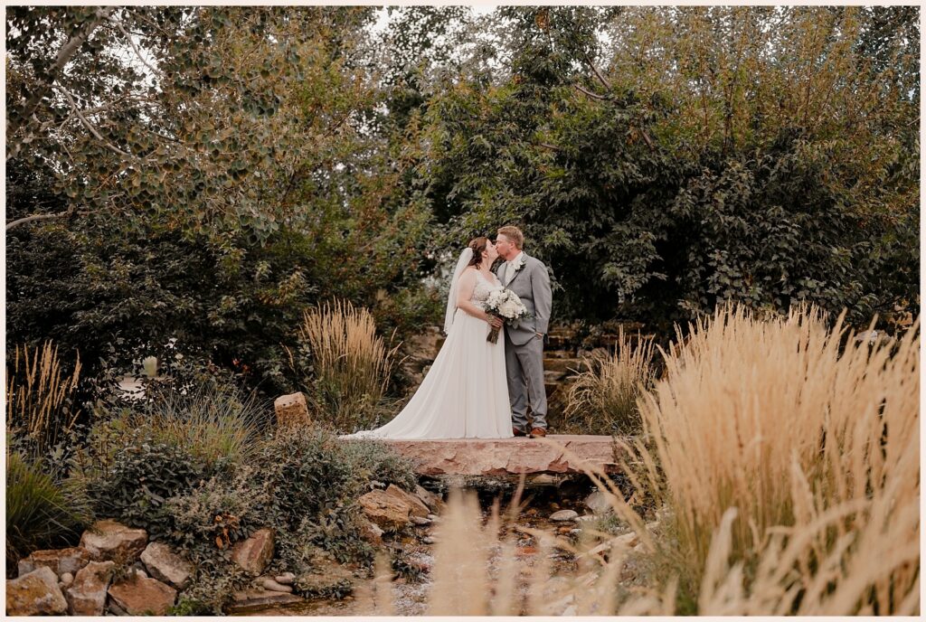 Couple kiss on the stone bridge at their Brookside Gardens wedding