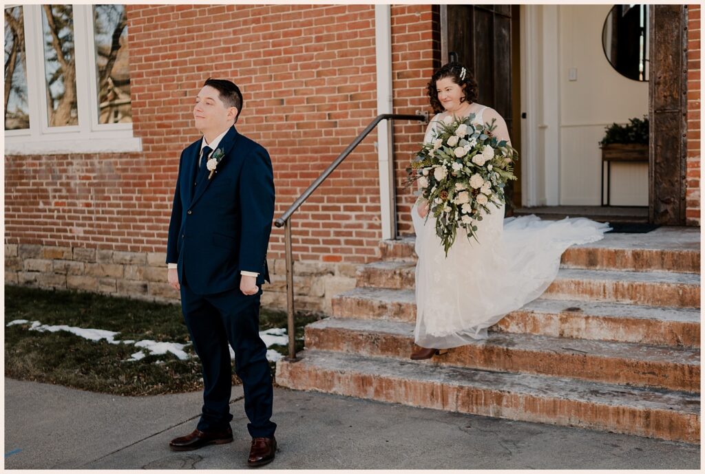 Bride walks up behind groom during first look during Sweetheart Winery wedding 