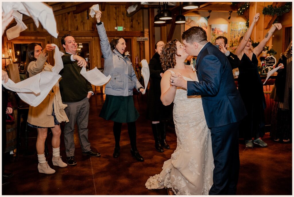 Couple kisses during the grand exit of their Sweetheart Winery wedding 